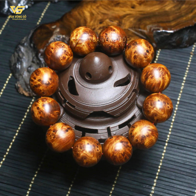 Cận cảnh vòng tay gỗ Nu Bách Xanh hạt tròn với vân xoắn hoa nổi rõ, trọng lượng nặng tay, gỗ già đanh chắc và có khả năng chìm nước.